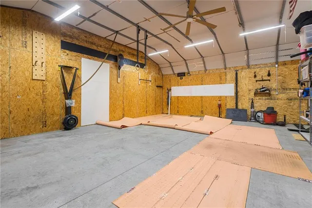 a bedroom with a bed a table and painting on the wall