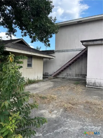 a backyard of a house with plants and brick wall
