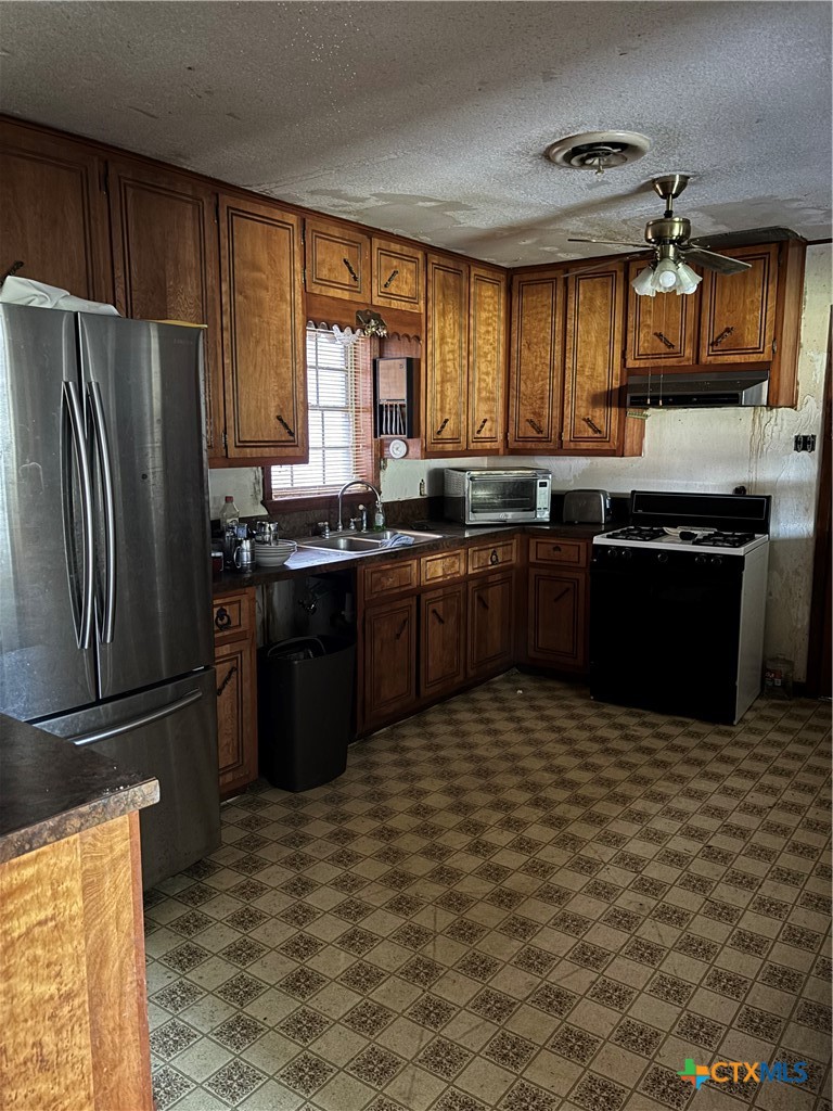 350 Grand Street Placedo, TX 77977 - Photo 8 of 15 a kitchen with stainless steel appliances granite countertop a stove a sink dishwasher a refrigerator and a microwave