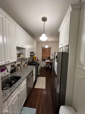 a kitchen with granite countertop a refrigerator stove top oven and sink