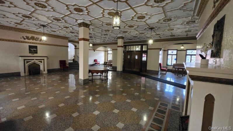143 Garth Road, Unit 1J Scarsdale, NY 10583 - Photo 5 of 24 a lobby with furniture and a chandelier