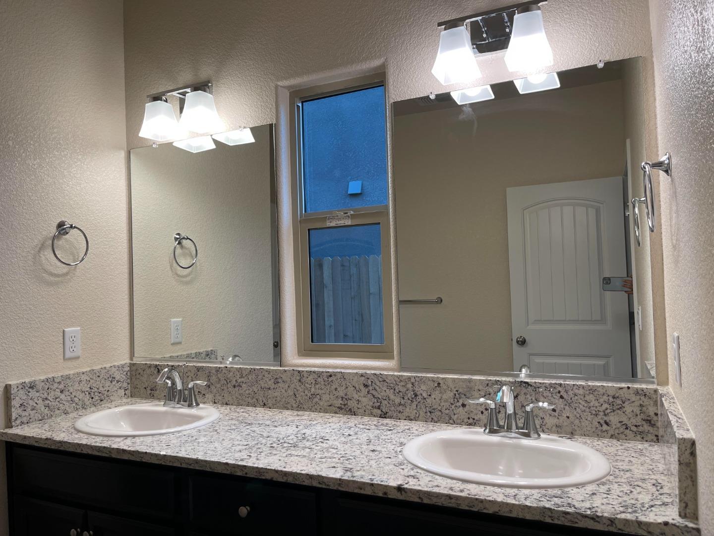 2411 Gabriel Drive Merced, CA 95340 - Photo 11 of 22 a bathroom with a granite countertop sink a light fixture and a mirror