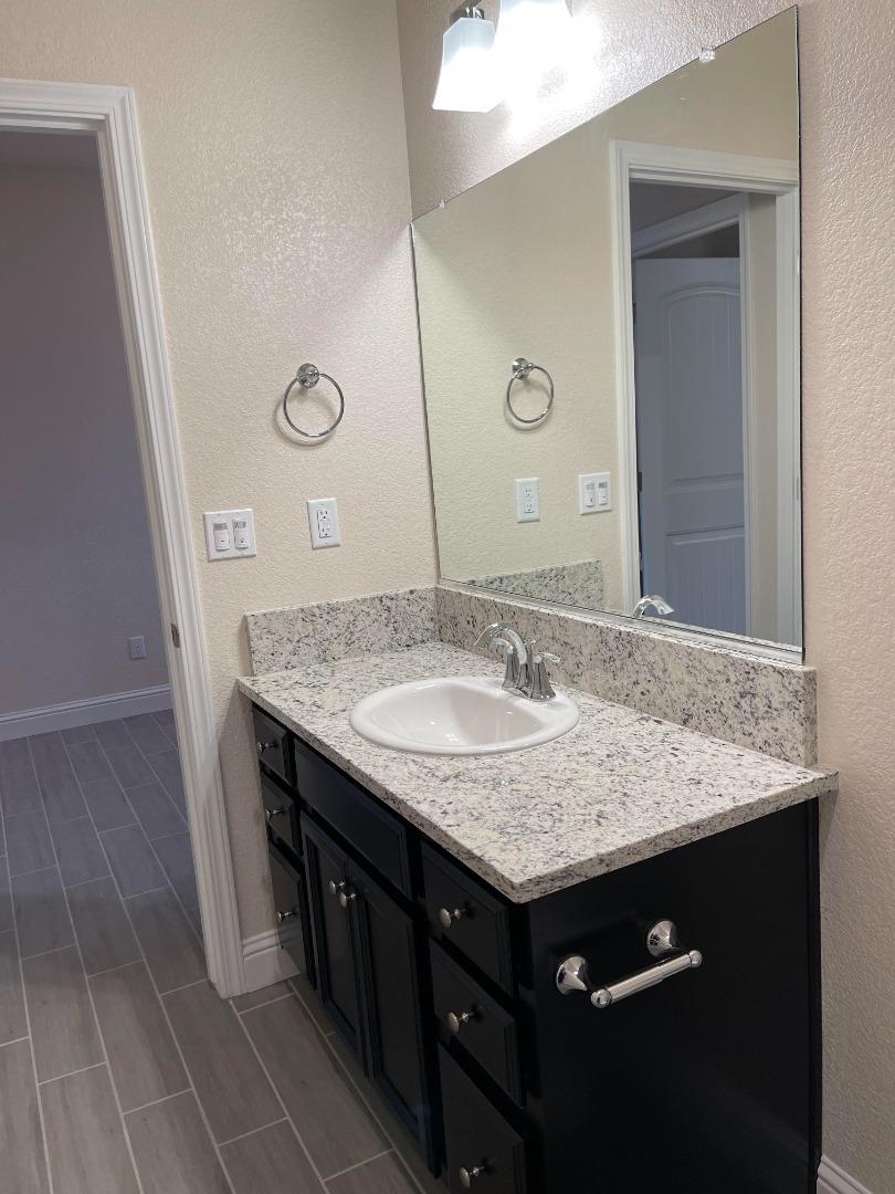 2411 Gabriel Drive Merced, CA 95340 - Photo 14 of 22 a bathroom with a sink a vanity and a mirror