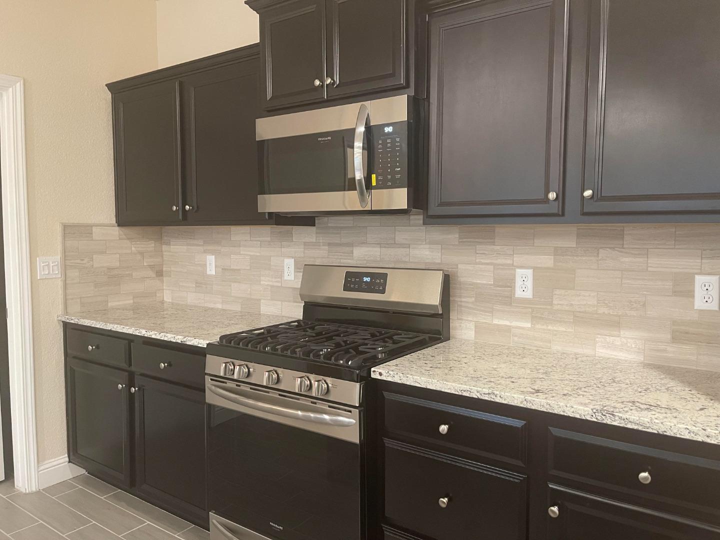 2411 Gabriel Drive Merced, CA 95340 - Photo 3 of 22 a kitchen with granite countertop a sink cabinets and stainless steel appliances
