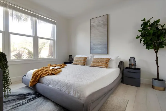 a bedroom with a bed and a potted plant