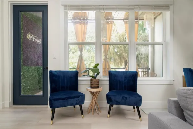 a living room with furniture kitchen view and a potted plant