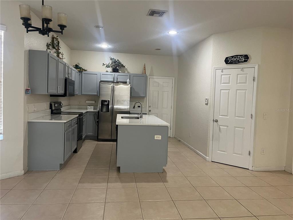 4943 Southwest 41st Place Ocala, FL 34474 - Photo 12 of 30 a kitchen with a sink a counter top space cabinets and stainless steel appliances