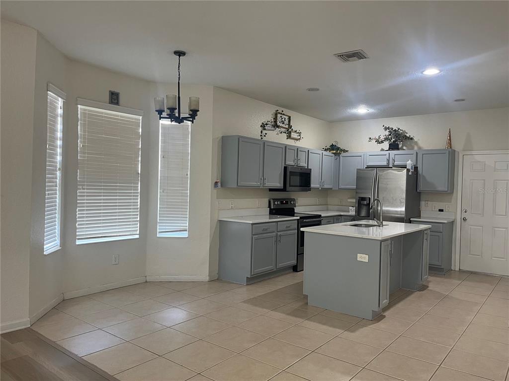 4943 Southwest 41st Place Ocala, FL 34474 - Photo 13 of 30 a kitchen that has a lot of cabinets in it and appliances