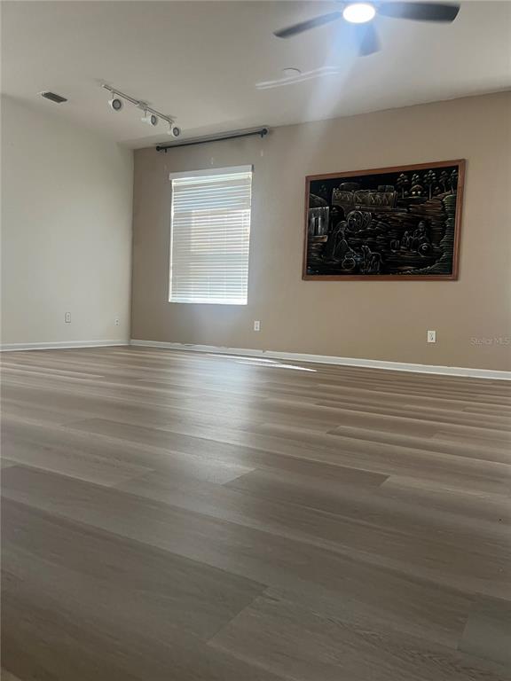 4943 Southwest 41st Place Ocala, FL 34474 - Photo 4 of 30 a view of a livingroom with wooden floor and a ceiling fan