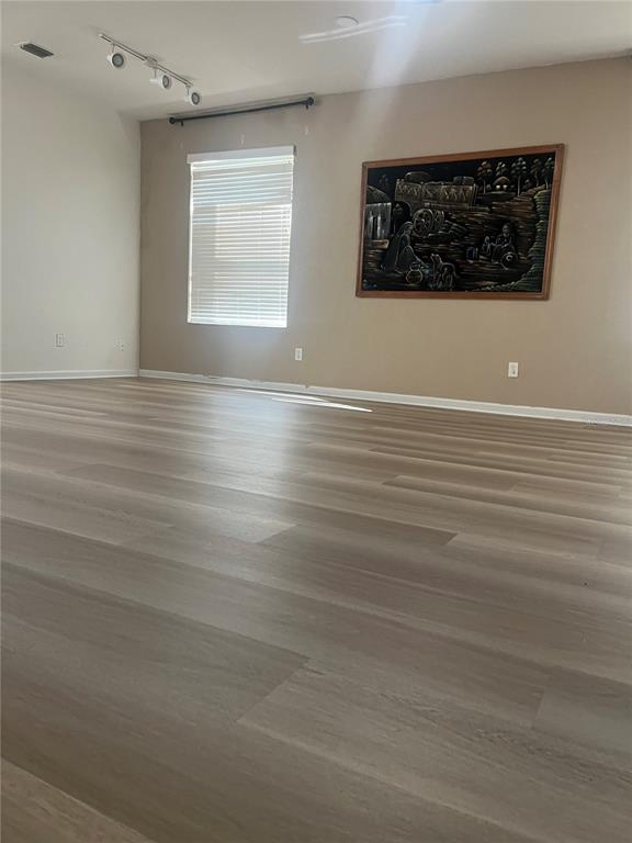 4943 Southwest 41st Place Ocala, FL 34474 - Photo 6 of 30 an empty room with wooden floor and windows
