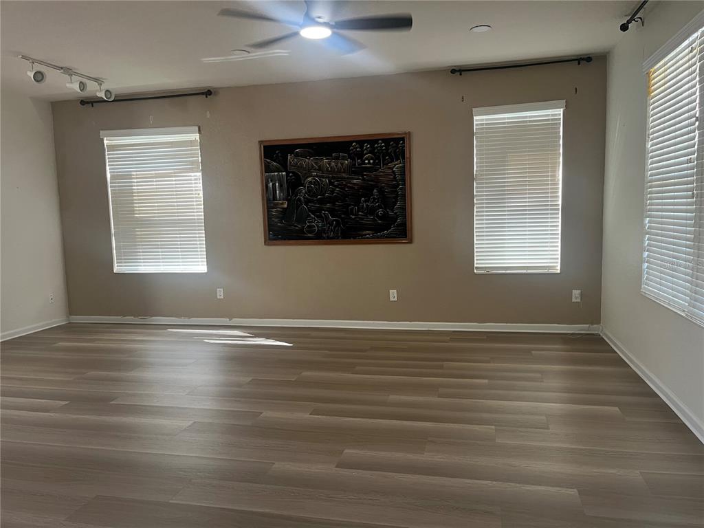 4943 Southwest 41st Place Ocala, FL 34474 - Photo 7 of 30 a view of an empty room with wooden floor and a window
