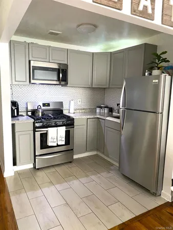 a kitchen with stainless steel appliances granite countertop a stove a sink and a refrigerator
