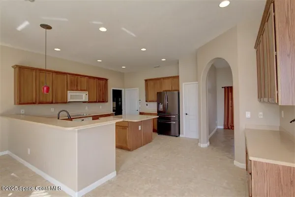 a kitchen with stainless steel appliances a refrigerator stove top oven and sink