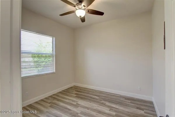 a view of an empty room with a window and closet