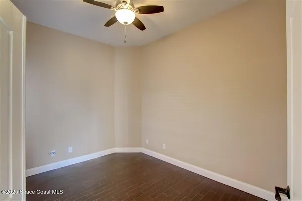 a view of an empty room with a chandelier fan
