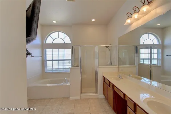 a bathroom with a granite countertop bathtub a sink and a large window