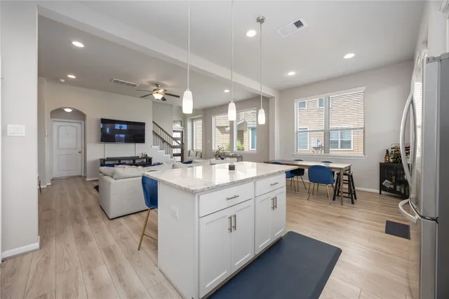 a large white kitchen with lots of counter space and painting on the wall