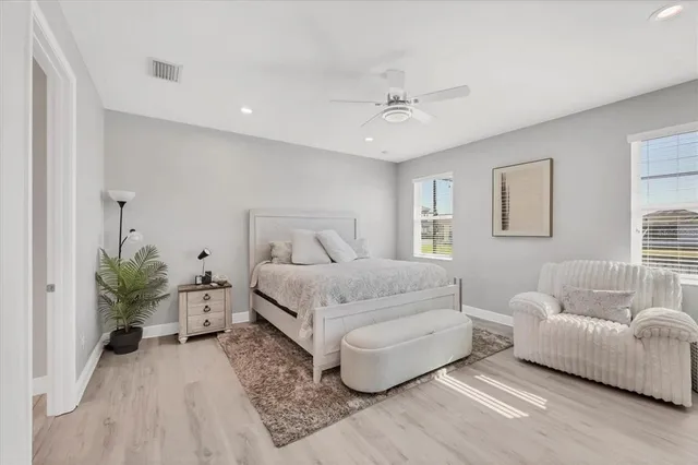 a bedroom with a large bed chandelier and a couch