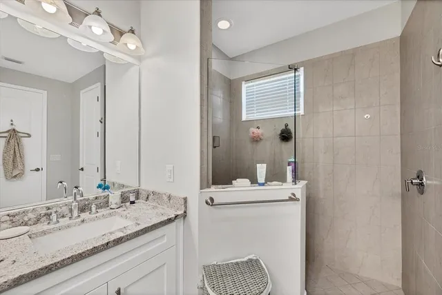 a bathroom with a granite countertop sink a toilet and a mirror