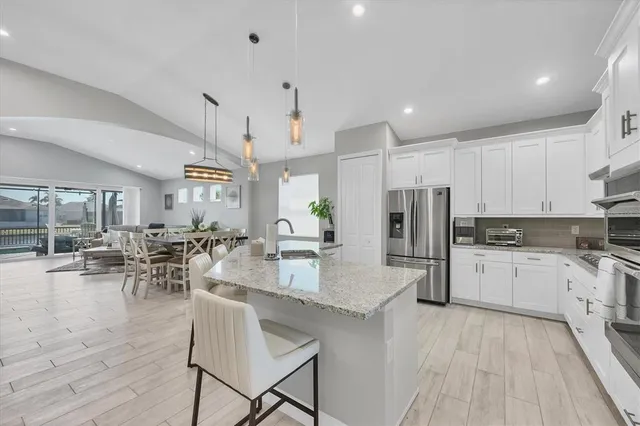 a kitchen with granite countertop a refrigerator stove top oven and sink