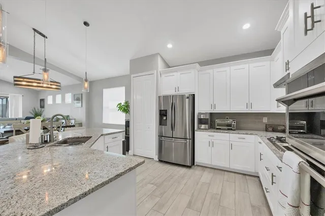 a kitchen with white cabinets and appliances