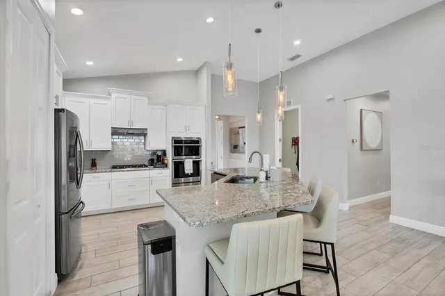 a kitchen with stainless steel appliances kitchen island granite countertop a sink and cabinets