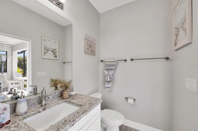 a living room with furniture a ceiling fan and a large window