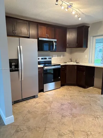 a large kitchen with cabinets and stainless steel appliances