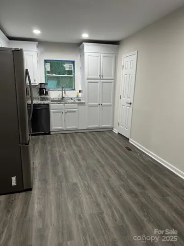 a kitchen with a sink a refrigerator and cabinets