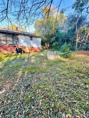 a view of a yard with plants and a bench