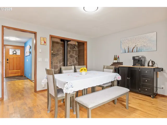 a dining hall with stainless steel appliances kitchen island granite countertop a table chairs and a refrigerator