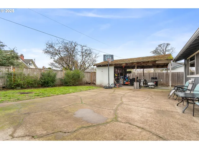 a backyard of a house with plants and wooden fence