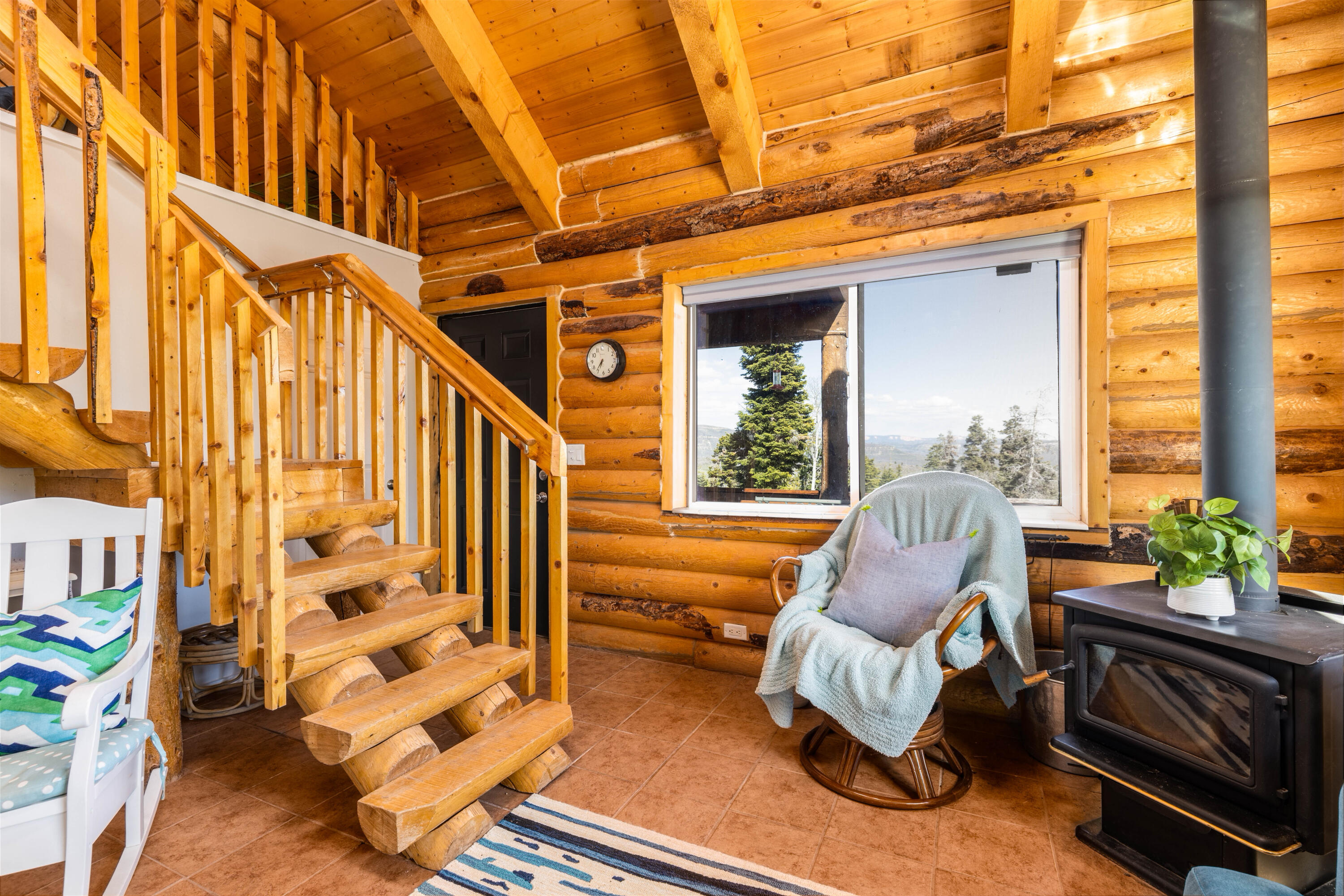 706 West Tranquility Drive Springdale, UT 84767 - Photo 6 of 58 Cozy Reading Nook: View of the rocking chair by the wood stove and stairs.
