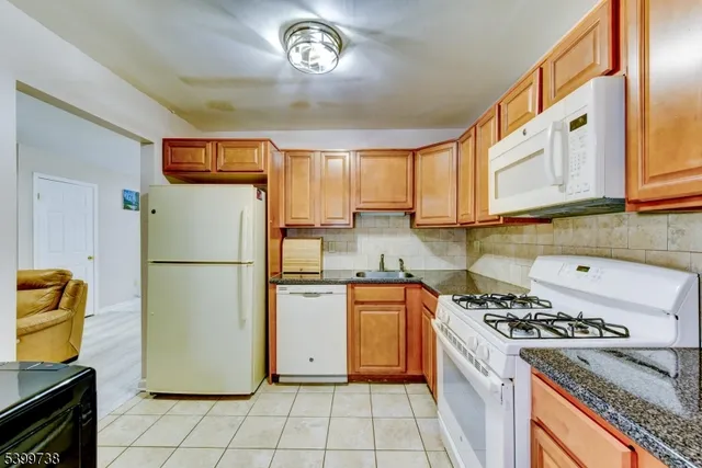 a kitchen with a refrigerator a stove top oven a sink and cabinets