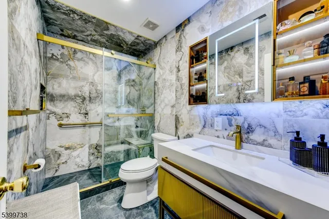 a bathroom with a sink a toilet and shower