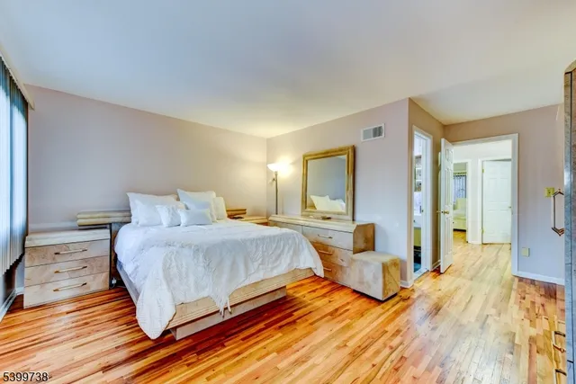 a bedroom with a bed and wooden floor