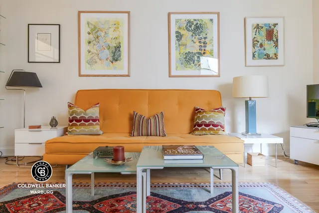 a living room with furniture a wooden floor and a window