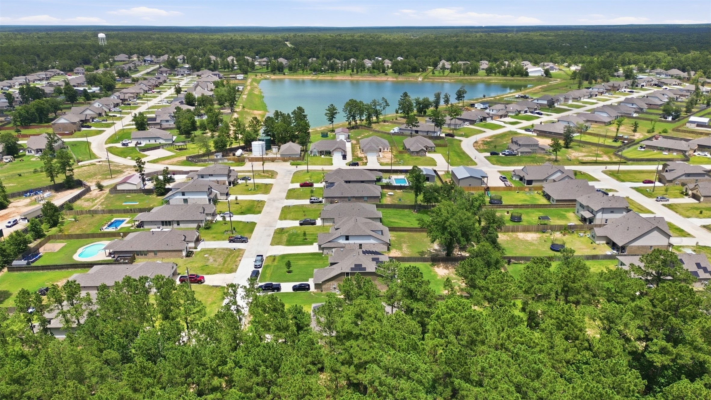 6310 Fawn Path Drive Conroe, TX 77303 - Photo 36 of 41 Beautiful community setting featuring a scenic pond, spacious homesites, and lush green surroundings, creating a peaceful and inviting atmosphere.