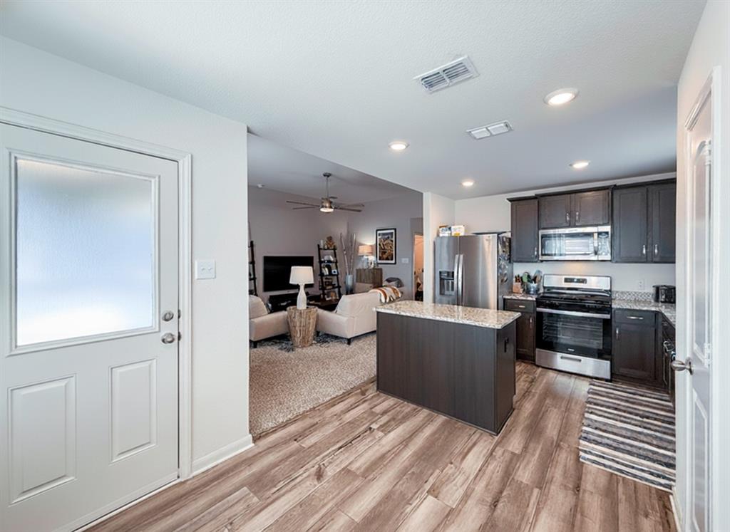 13507 Granite Park Road Ponder, TX 76259 - Photo 11 of 28 a kitchen with a refrigerator and a stove top oven