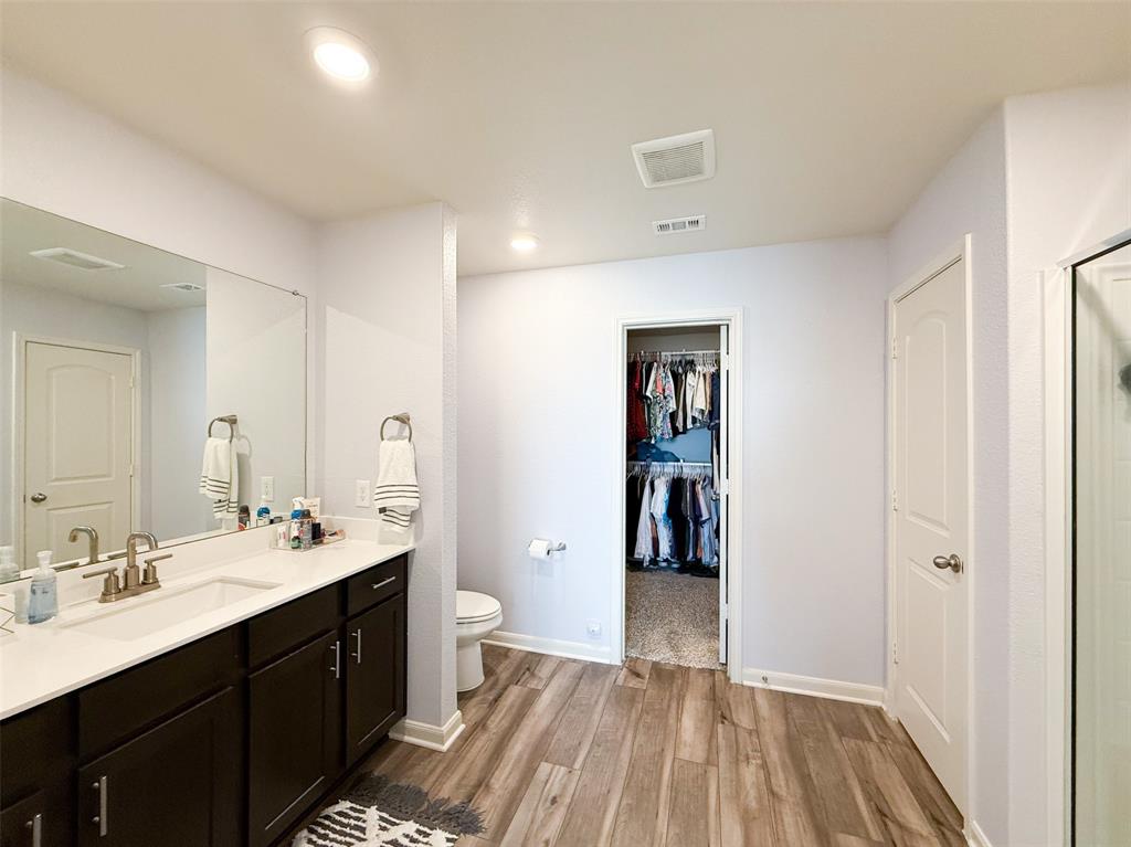 13507 Granite Park Road Ponder, TX 76259 - Photo 14 of 28 a spacious bathroom with a double vanity sink a mirror and a toilet