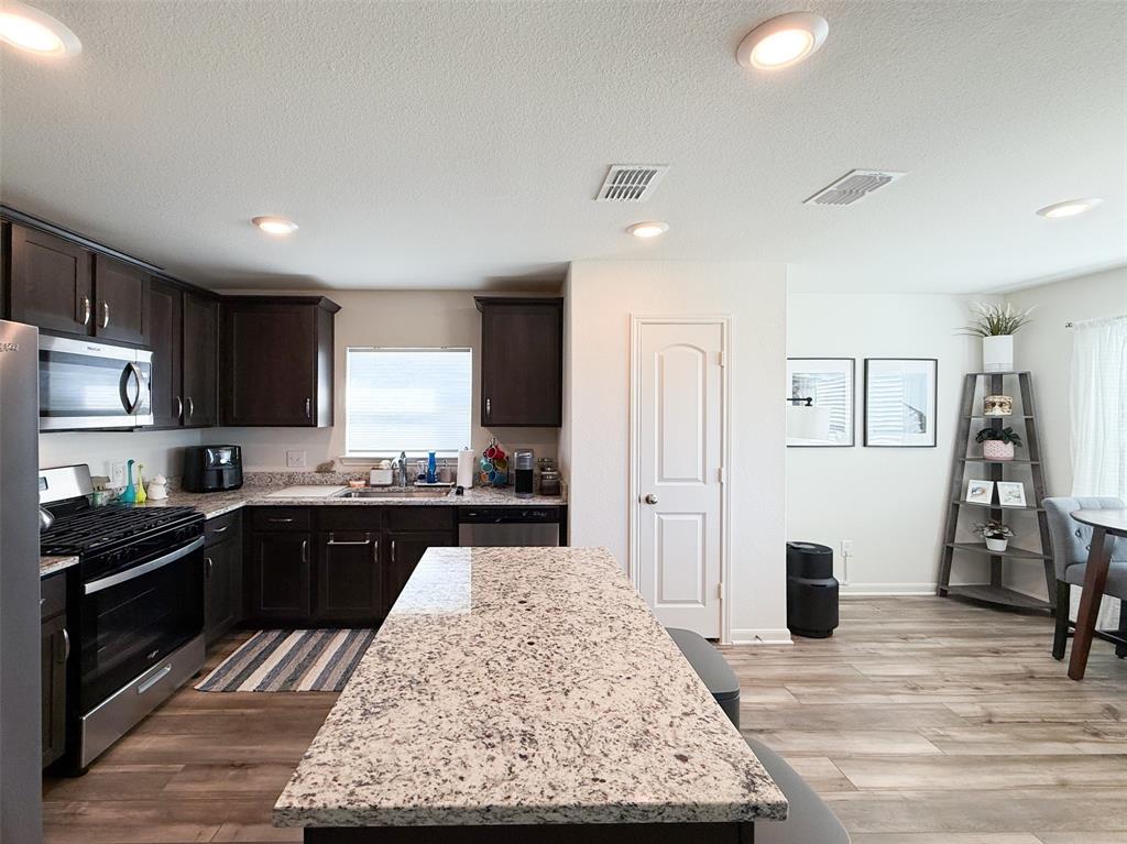 13507 Granite Park Road Ponder, TX 76259 - Photo 10 of 28 a kitchen with stainless steel appliances granite countertop a stove top oven a sink refrigerator and cabinets