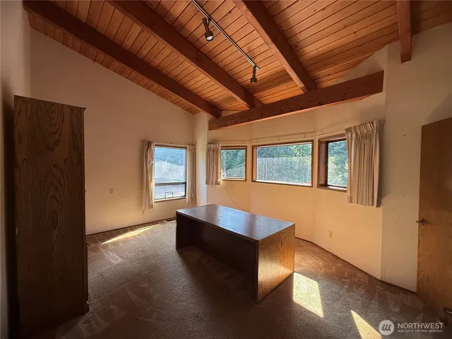 a view of an empty room with a fireplace and a window