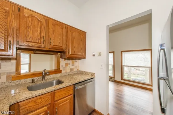 an empty room with wooden floor ceiling fan and windows