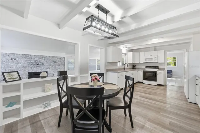 a kitchen with white cabinets stainless steel appliances and a window
