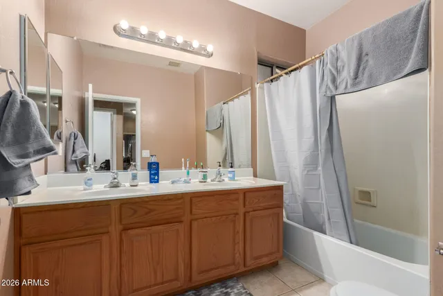 a bathroom with a double vanity sink mirror and shower