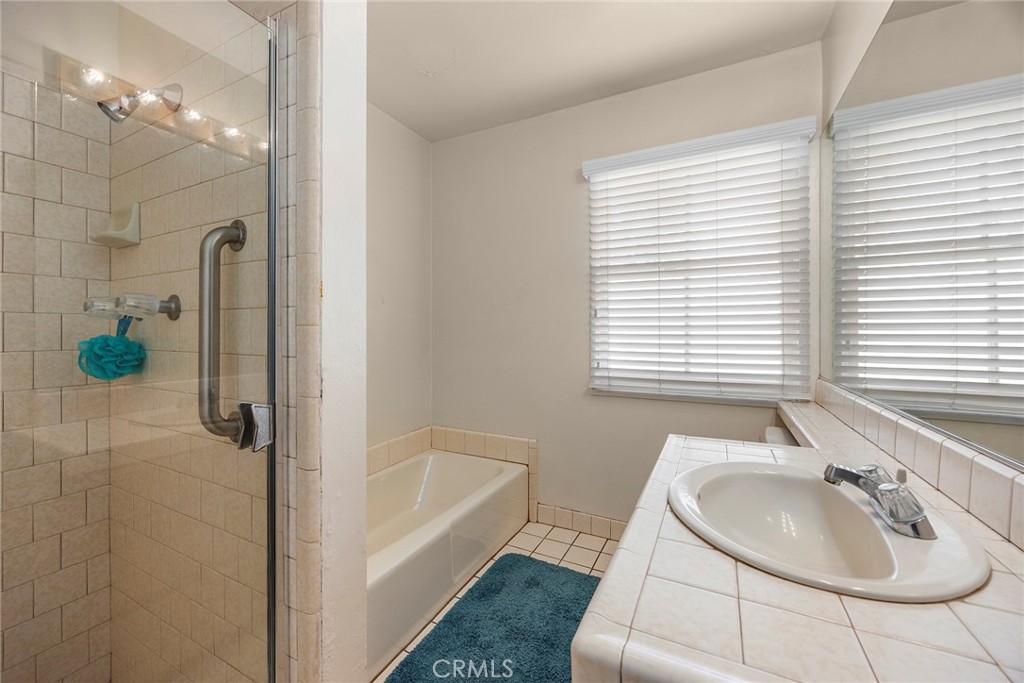 12342 Rea Circle Garden Grove, CA 92841 - Photo 16 of 27 a bathroom with a tub sink and mirror