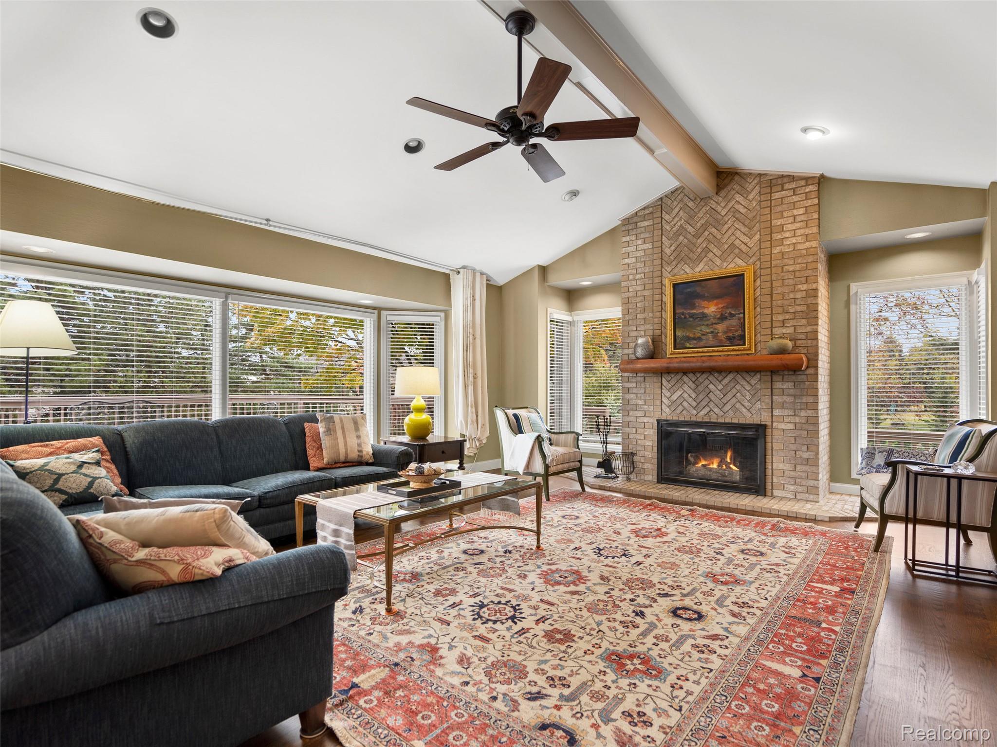 5724 Murfield Drive Rochester, MI 48306 - Photo 58 of 99 Living room featuring beamed ceiling, a ceiling fan, a brick fireplace, dark wood finished floors, and high vaulted ceiling