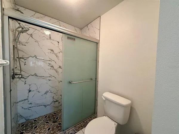 a white toilet sitting next to a shower curtain