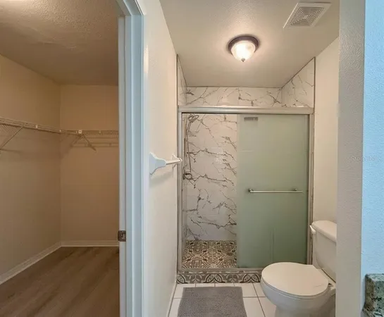 a bathroom with a shower a toilet and a window
