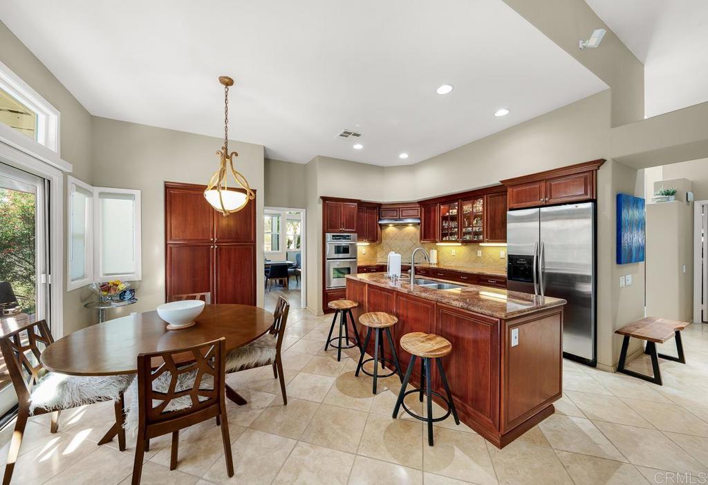 3762 Hidden Ridge Road Jamul, CA 91935 - Photo 6 of 29 a kitchen with stainless steel appliances granite countertop table chairs and a refrigerator